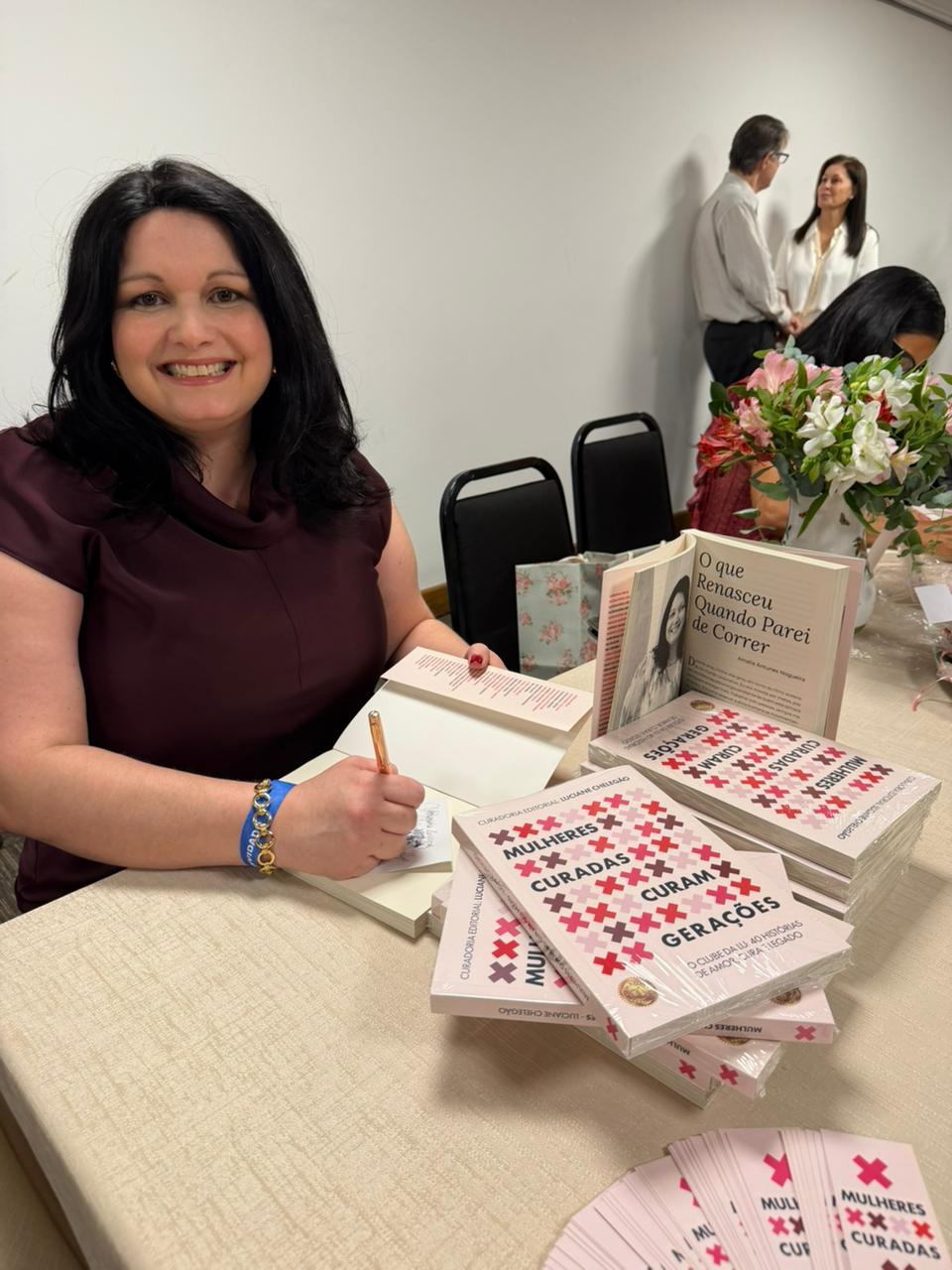 Amalia autografando Mulheres Curadas Curam Gerações