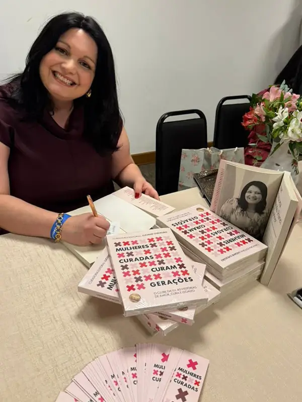 Amalia autografando exemplar